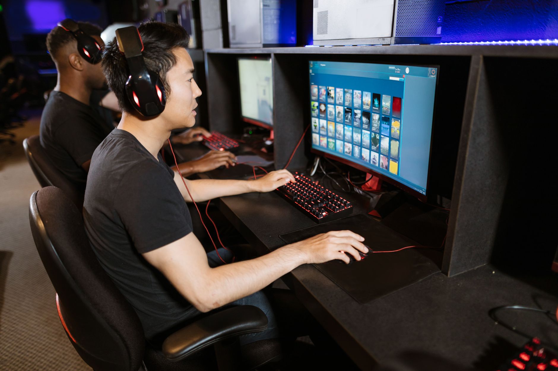 Sports Nutrition for Optimal Performance — Two young men play video games at a cyber cafe, showcasing modern gaming technology indoors.