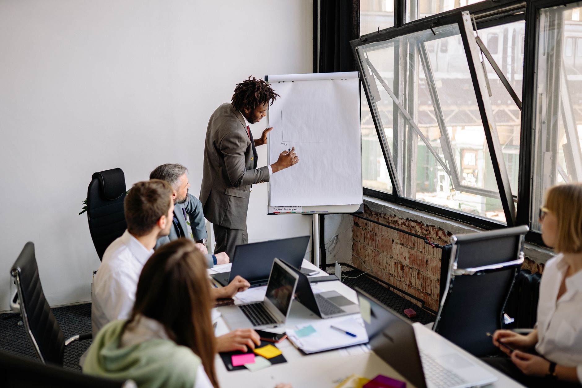 Introduction to Contemporary Business Strategy: Sustainable Business Growth — Diverse team engaged in a business meeting with a presentation in a modern office setting.