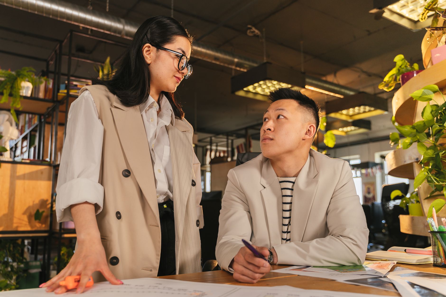 Creating Futures: Sustainable Enterprise and Innovation — Two business colleagues collaborating at a modern office desk. engaging discussion and teamwork.