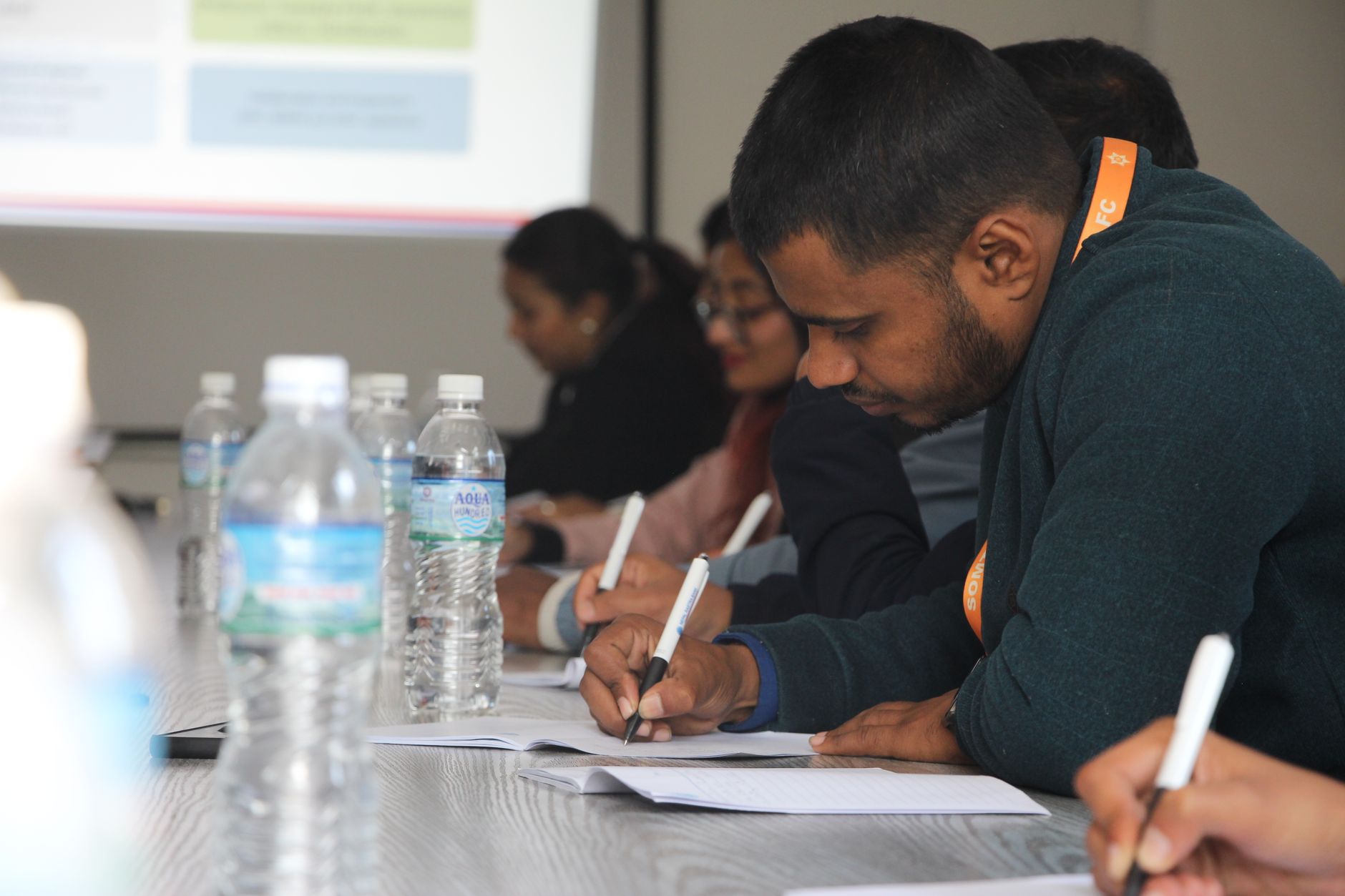 Social And Developmental Psychology — Focused students taking notes during a classroom seminar indoors.