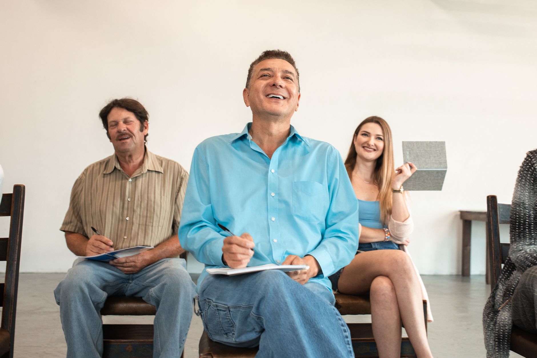 Visual Perception in a Psychological Context — A group of adults smiling and writing during an engaging classroom session.