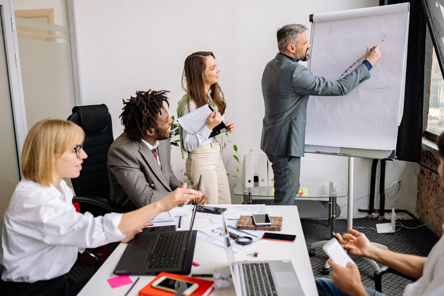 Contemporary HRMLeading, Managing and HR Development — Business professionals brainstorming and collaborating during a team meeting in a modern conference room.
