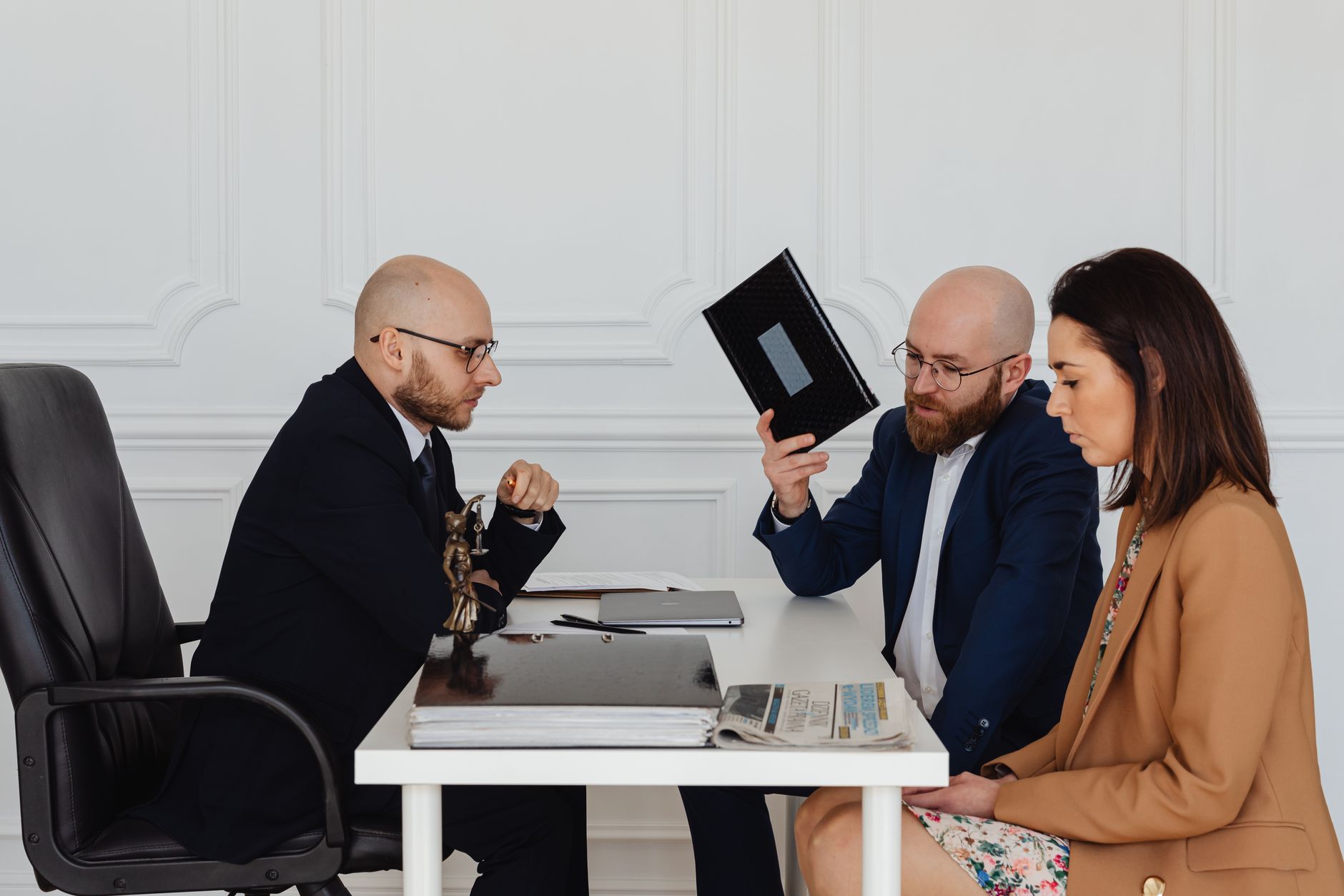 Contract Law — A couple in a legal consultation with a lawyer at an office desk.