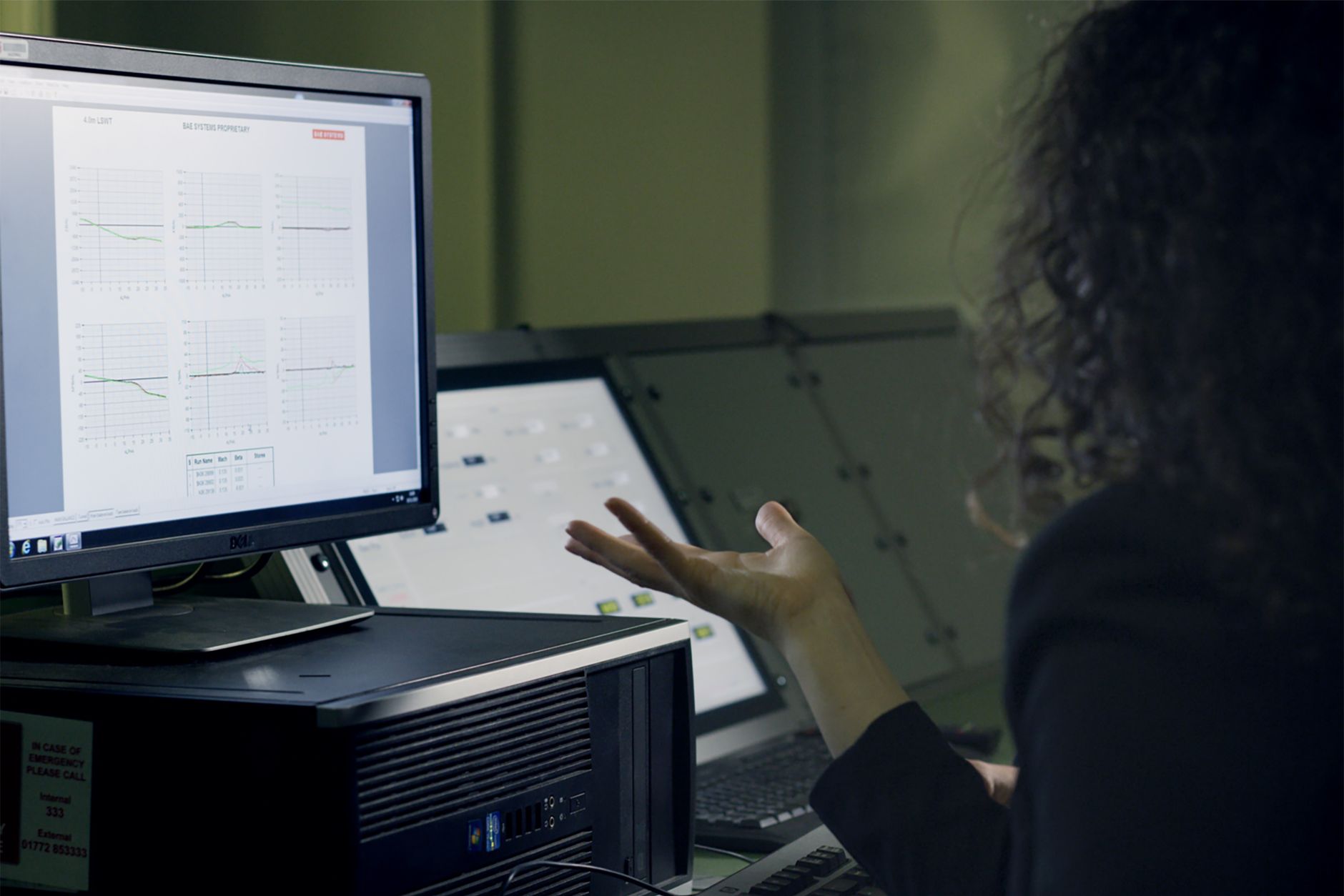 Graphical User Interface (GUI) — A woman analyzes data on a computer screen in a modern office setup, focusing on technological research.