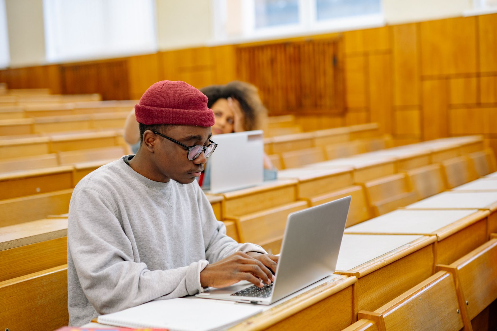 Advanced Deep Machine Learning — Students focus on laptops in a spacious university lecture hall, learning and working digitally.
