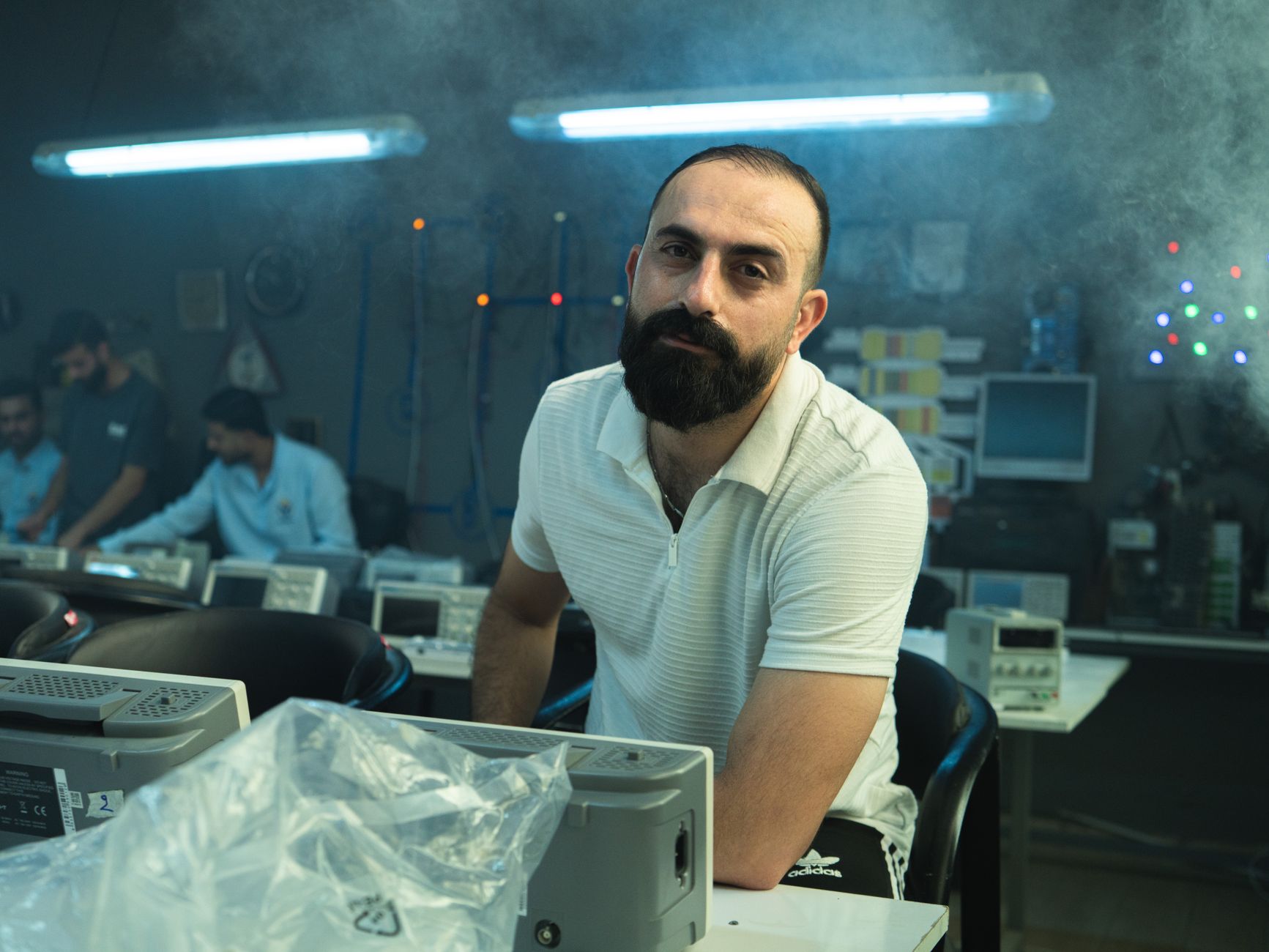 Hypertrophy for Sport and Exercise — Man in a technology workshop surrounded by electronic devices, baghdad, iraq.
