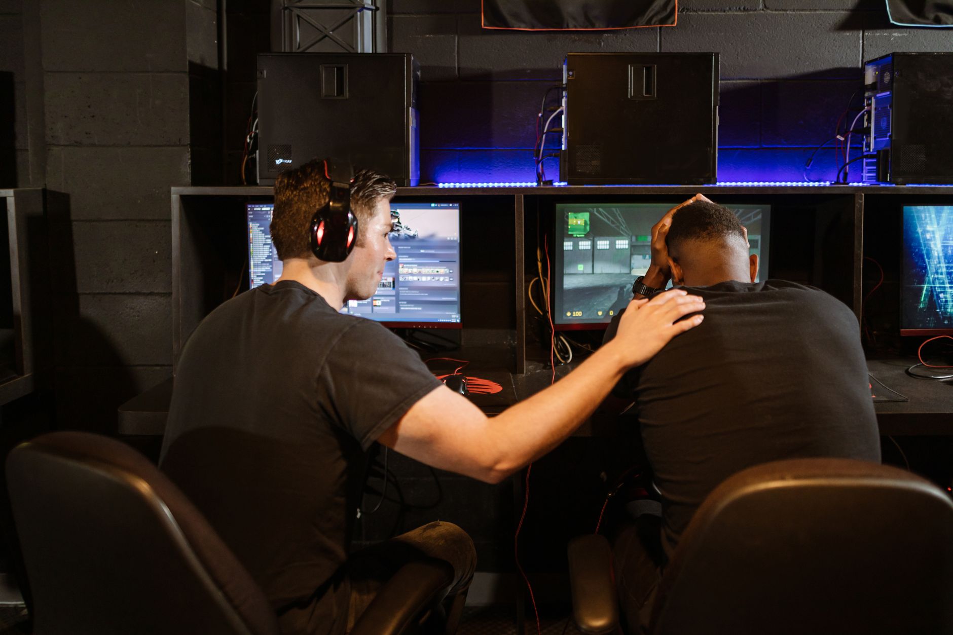 Musculoskeletal Nutrition Support in Sport — Two gamers support each other in a cyber cafe, navigating challenges together.