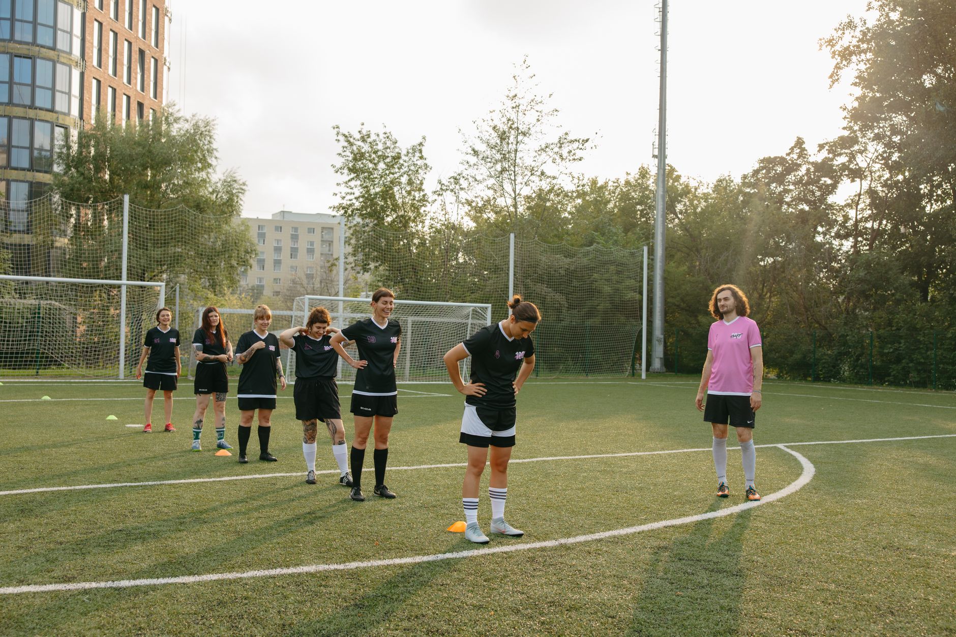 Bowling Coaching in Cricket — Women's soccer team practices drills on a sunny outdoor field with coach observing.