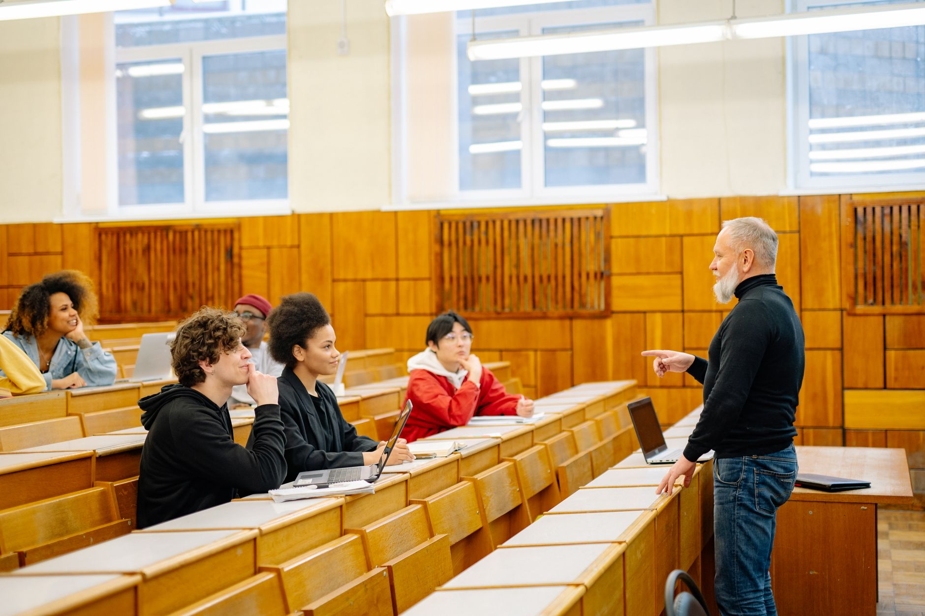 The Biochemistry and Biology of Cells — A diverse group of university students engaging with a professor during a classroom lecture.