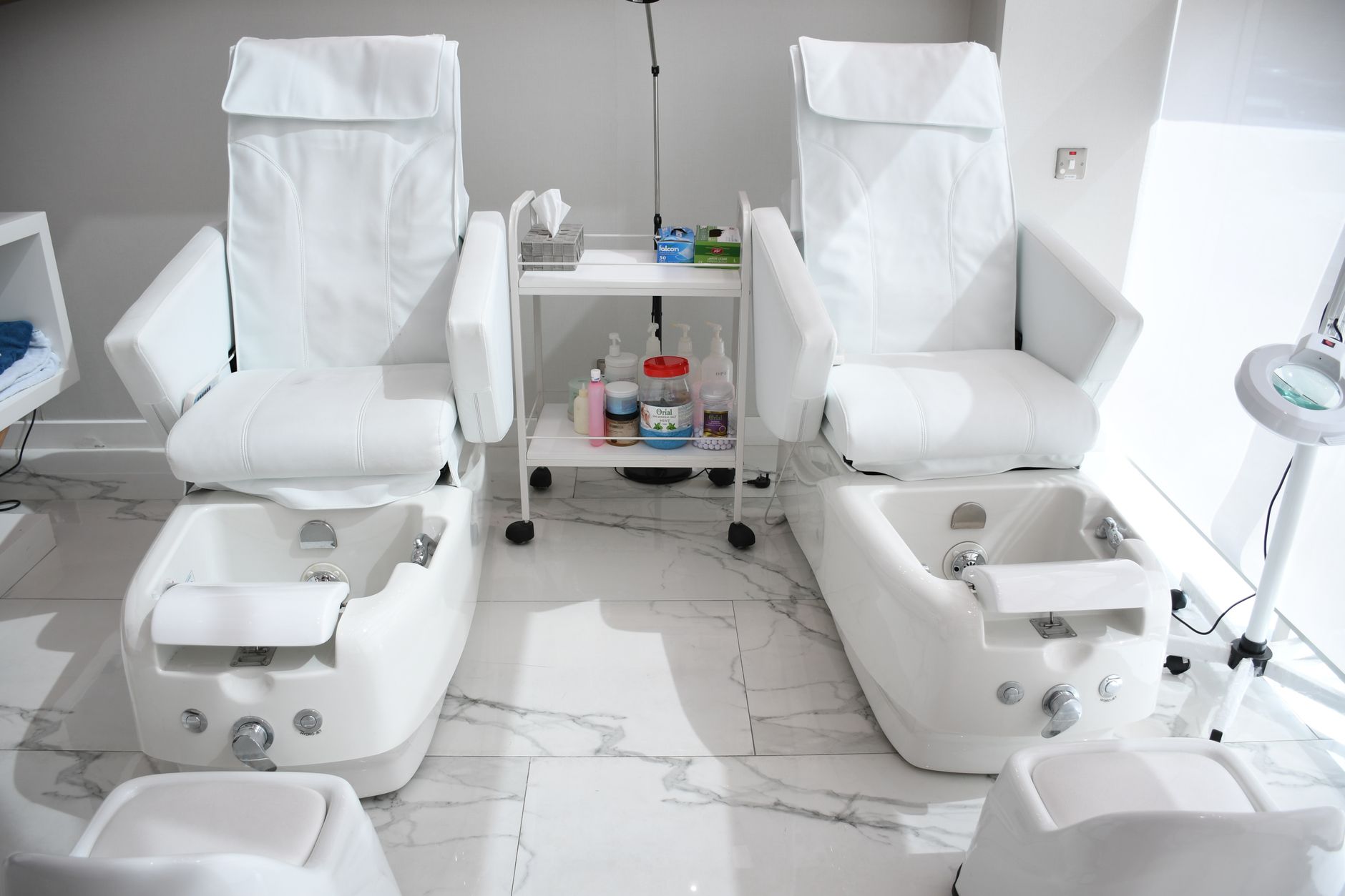 Pedicure treatments — Elegant white spa chairs ready for pampering treatments in abu dhabi salon.