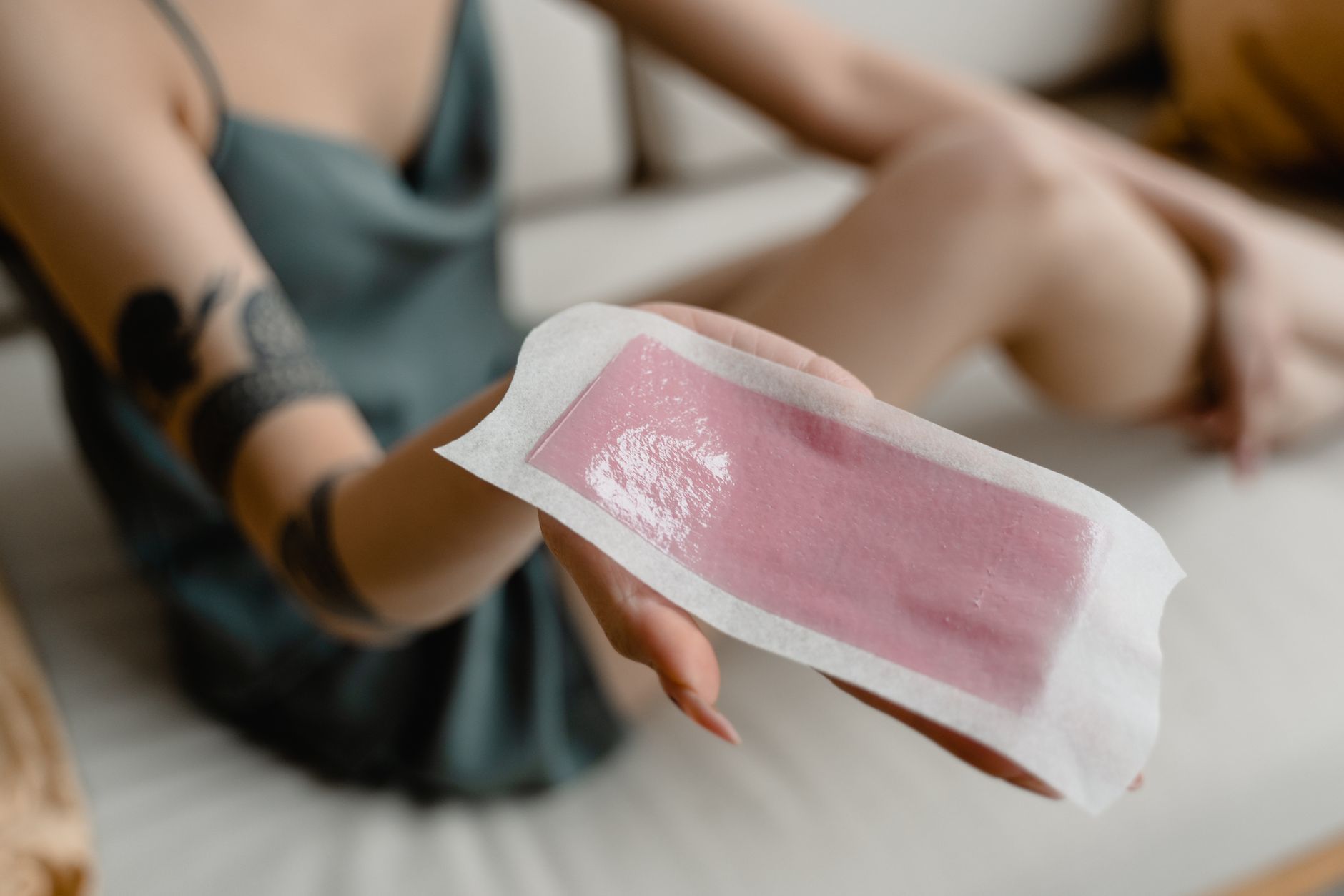 Waxing treatments — Close-up of a woman's hand holding a hair removal wax strip. perfect for beauty and skincare content.