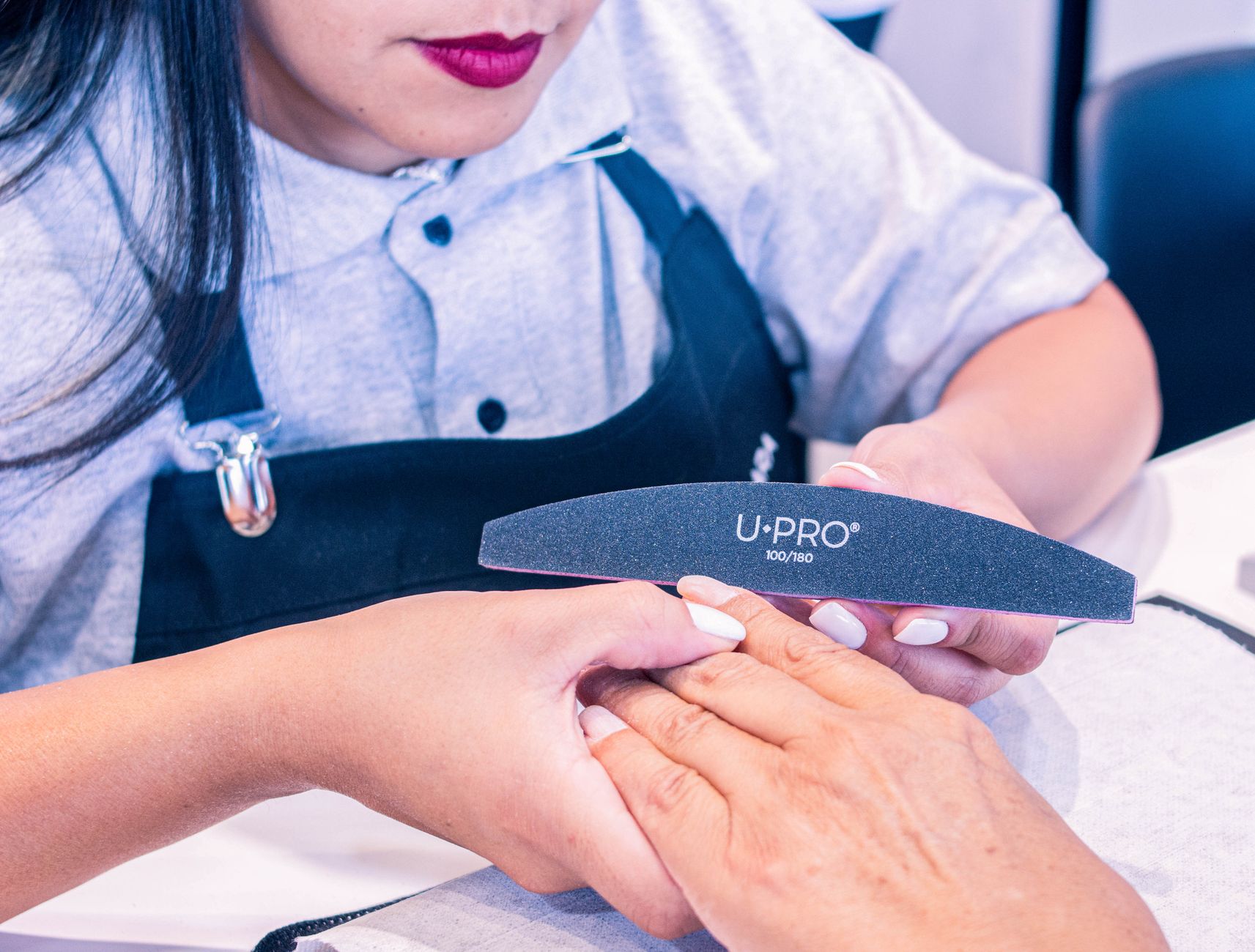 Makeup techniquesUV Gel nail services — A professional nail technician provides a manicure service in a beauty salon, focusing on nail care.