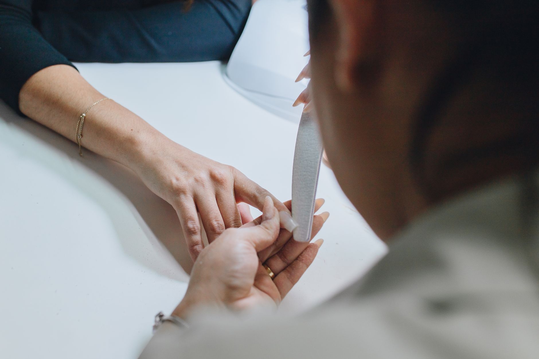 Promotional activities — Close-up of a manicurist filing nails during a professional manicure session in a salon.