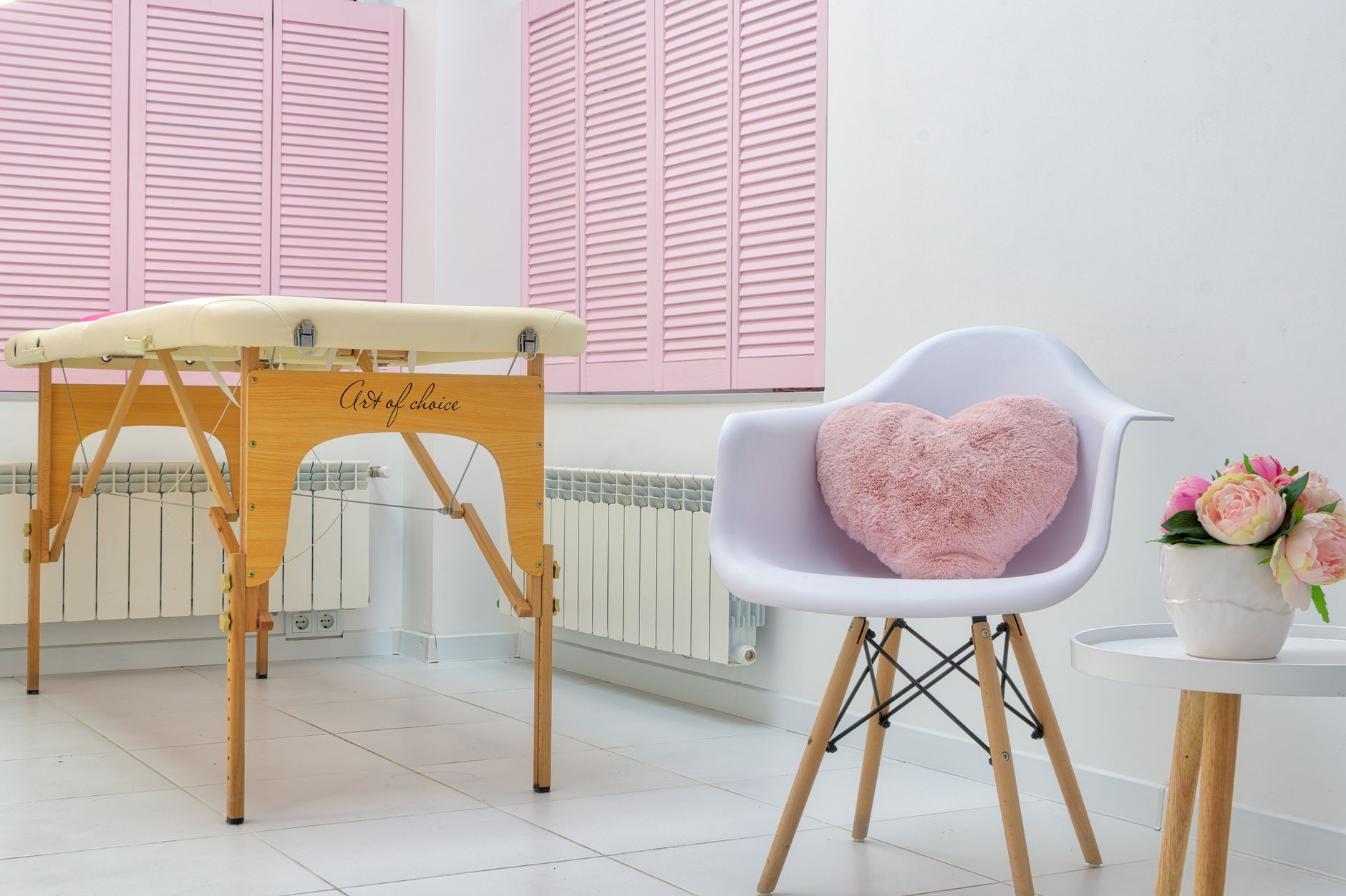 Intimate waxing — Creative design of massage parlor with table and decorative heart shaped cushion in armchair on tiled floor