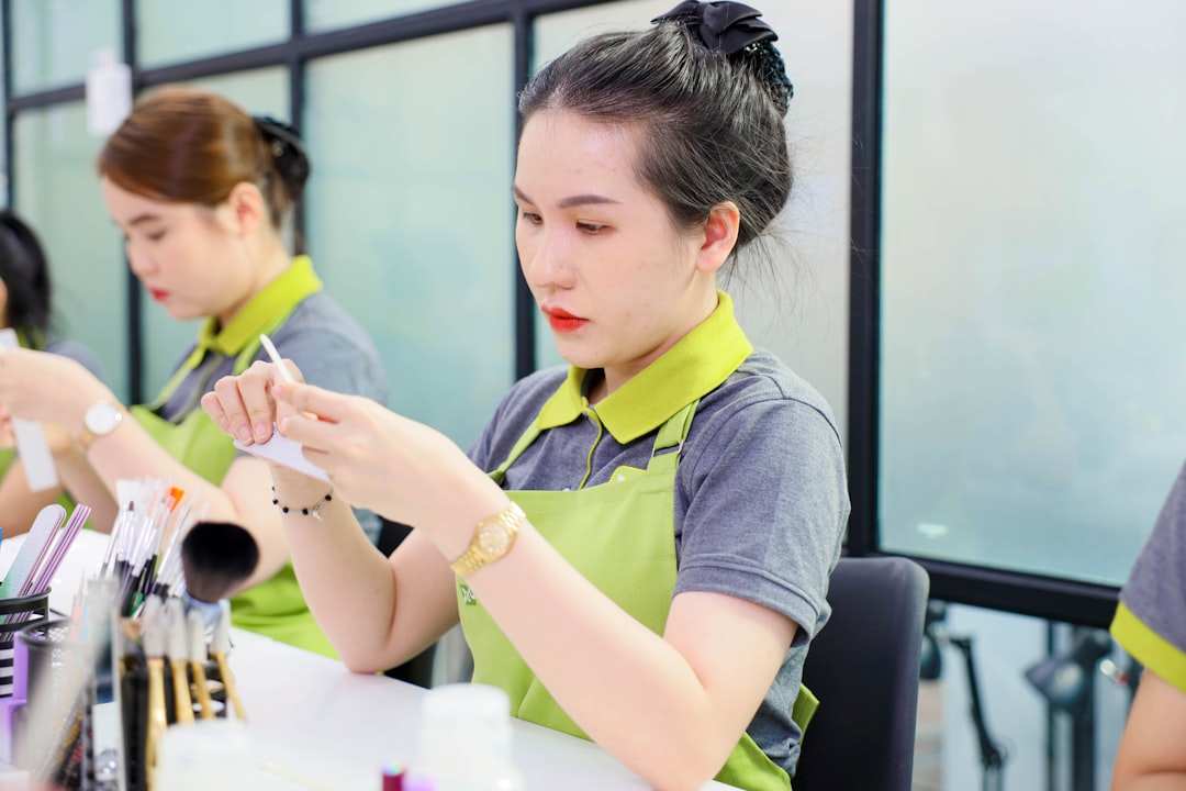 Promotional activities — A group of women sitting at a table with makeup brushes