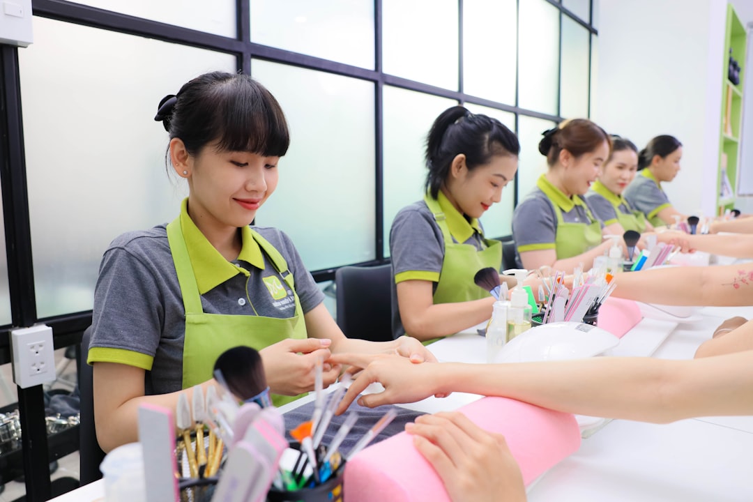 Health, safety, and hygiene — A group of women sitting at a table with makeup brushes