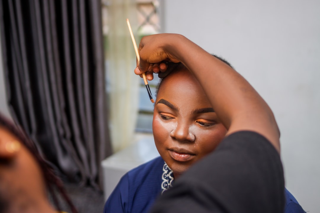 Client consultation — Makeup artist applying makeup to a woman's face.