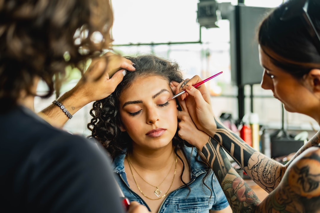 Implement health, safety, and hygiene — A woman getting her makeup done by a tattoo artist