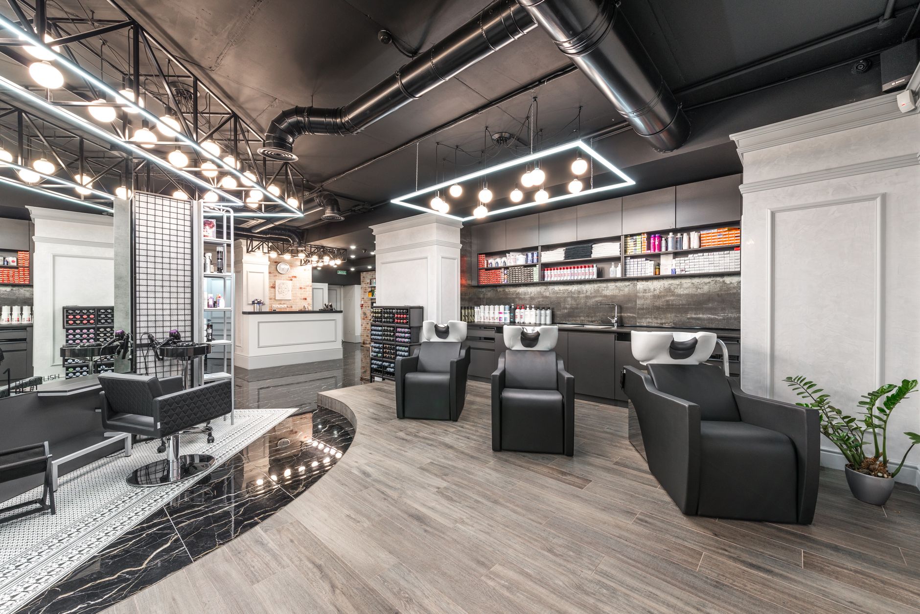 Creatively colour and lighten hair — Comfortable backwash chairs with sinks near potted plant placed in contemporary beauty salon with bright illumination and abundance of cosmetology products