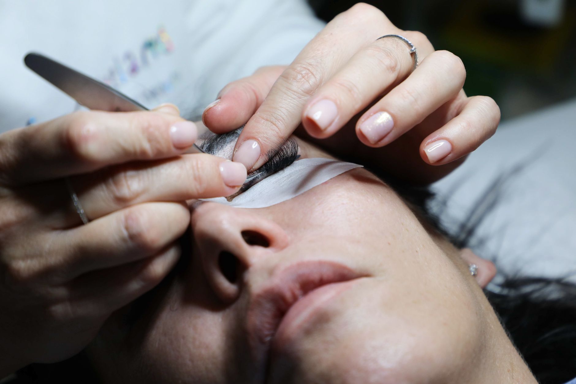 Hair extensions — Detailed close-up of a woman receiving eyelash extensions in a professional beauty salon.