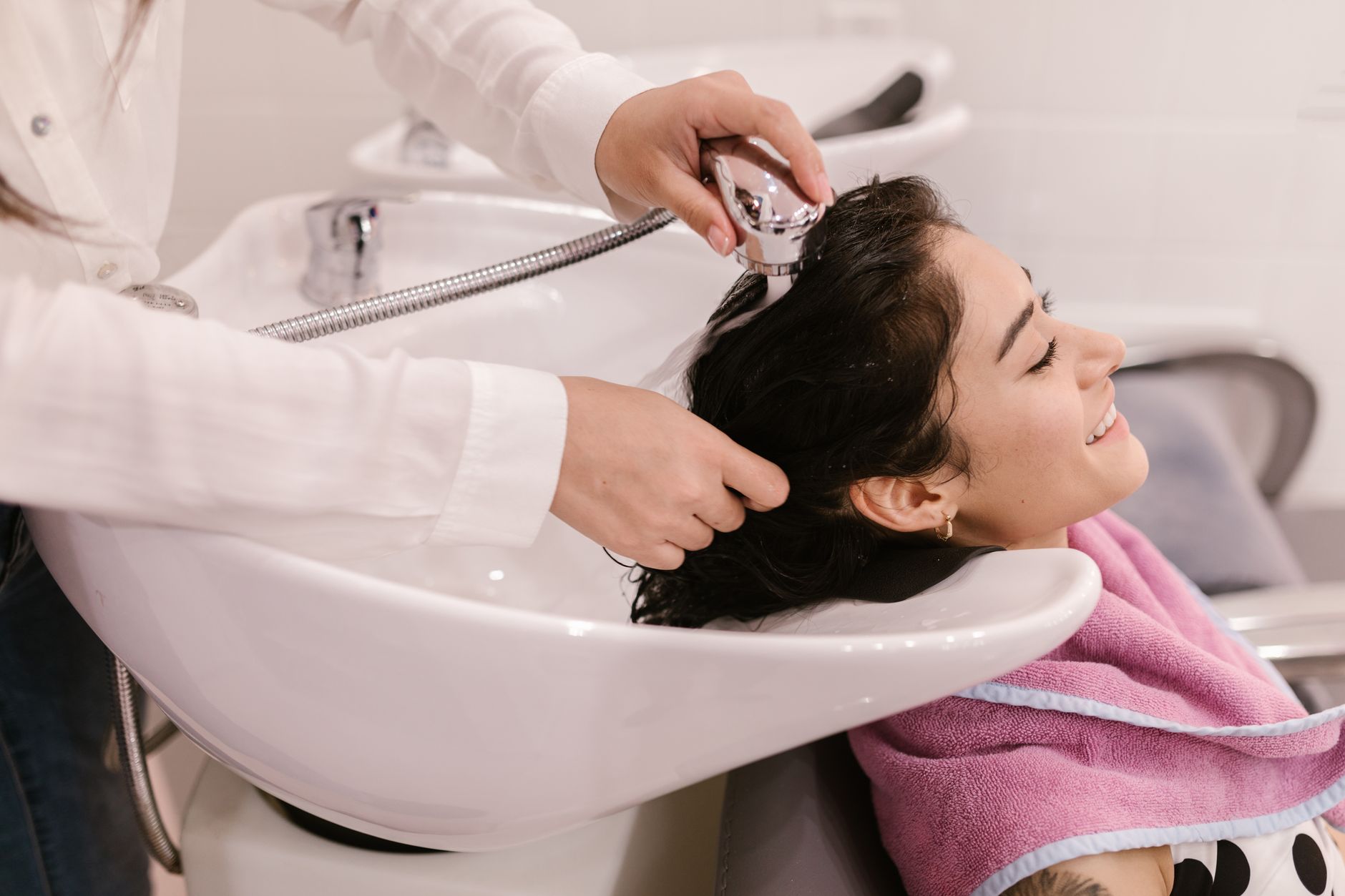 Relax hair — A young woman enjoys a relaxing hair wash at a modern beauty salon.