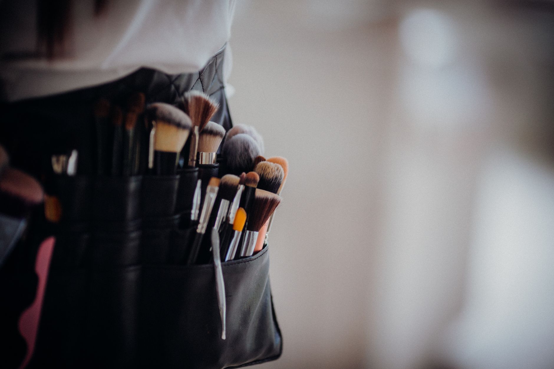 Promotional activities — Close-up of a collection of professional makeup brushes in a belt, ready for use.