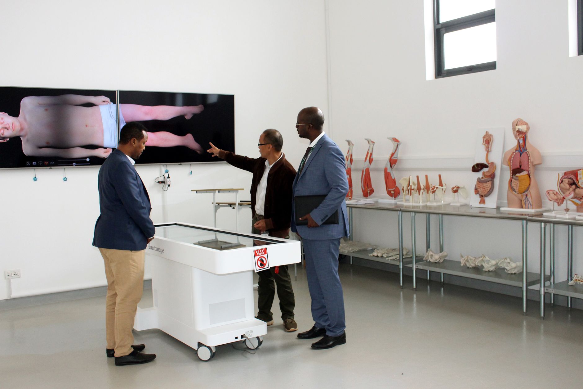 Anatomy, physiology and pathology — Three professionals discussing anatomy in a modern laboratory environment.