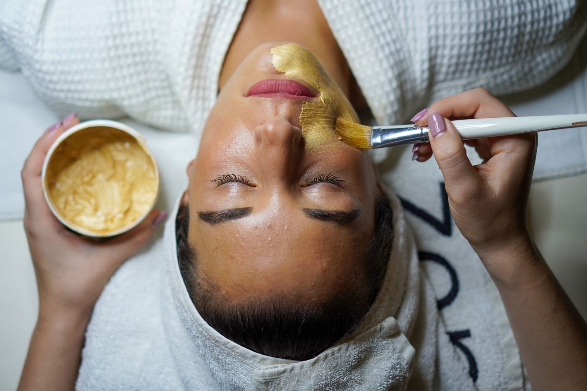 Wet spa and wellness experiences — A woman enjoying a gold facial mask for relaxation and skincare at a spa.