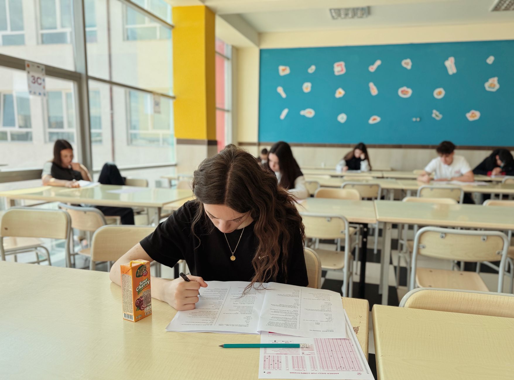 Thai massage — Student concentrated on exam in classroom setting with natural light.