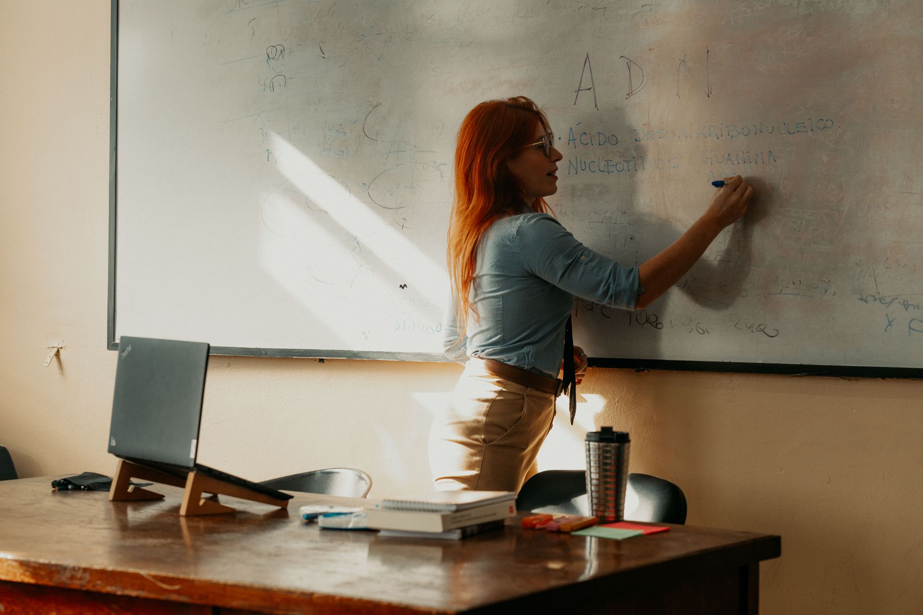 Holistic head, neck and shoulder massage — A teacher instructs at a whiteboard inside a buenos aires classroom, focusing on lesson planning.