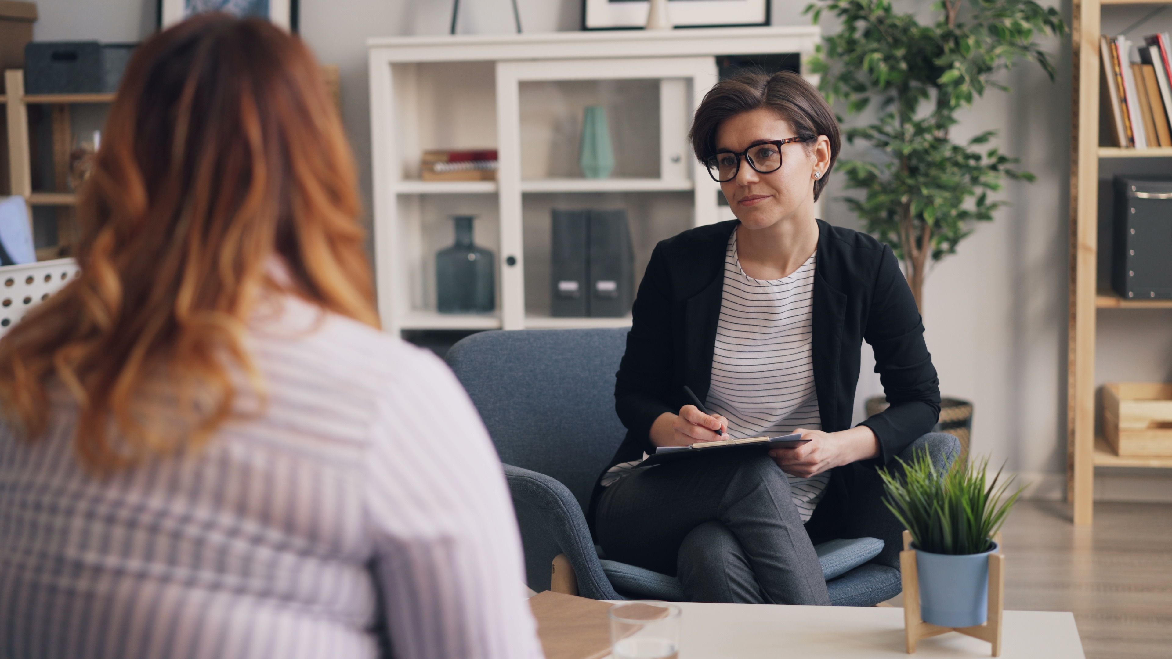 Pathway Level 7 Diploma in Psychology — A teacher leads an interactive discussion with diverse adult students in a modern classroom setting.